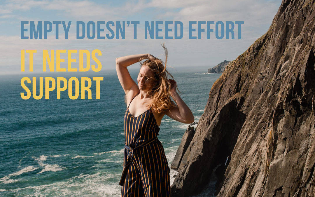 "empty doesn't need effort it needs support." photo of Lumalia standing on a cliff edge with her hair blowing and arms up